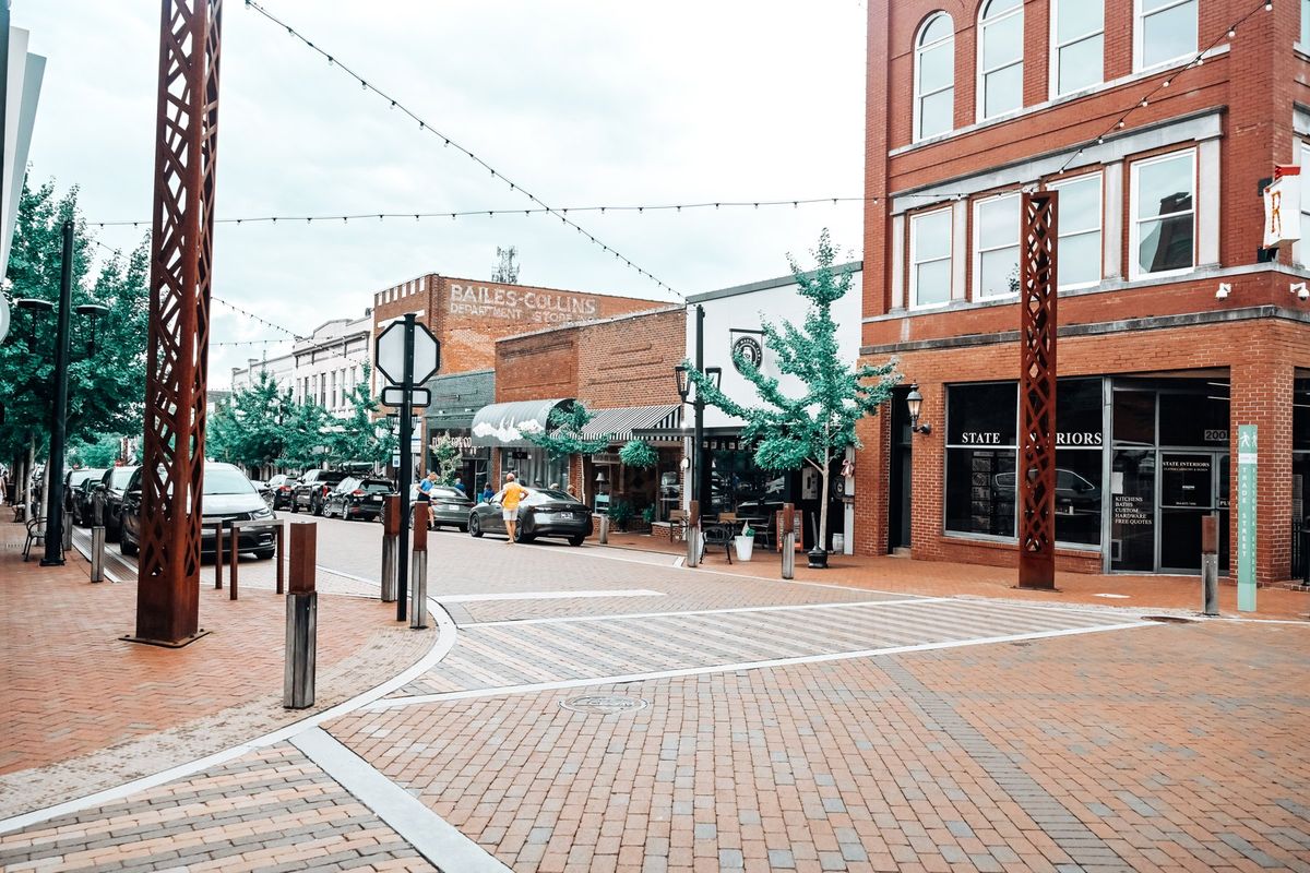 Planters, clean storefronts, and brick sidewalks on a cared-for main street